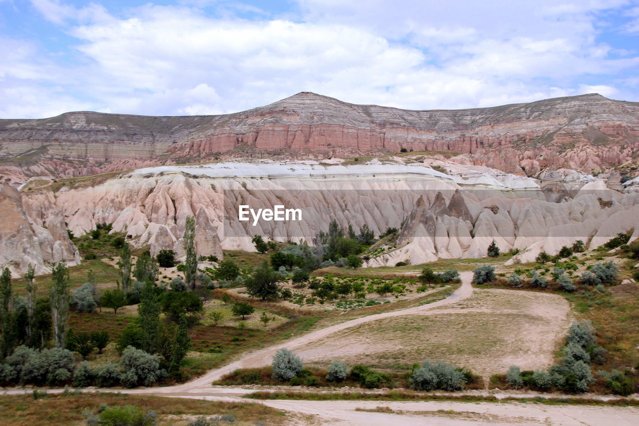 The view on the valley in the mountains with a cart on the foreground.