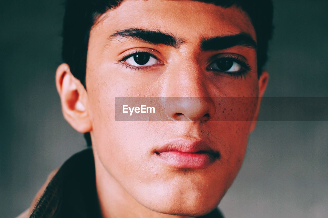 Close-up portrait of young man against wall