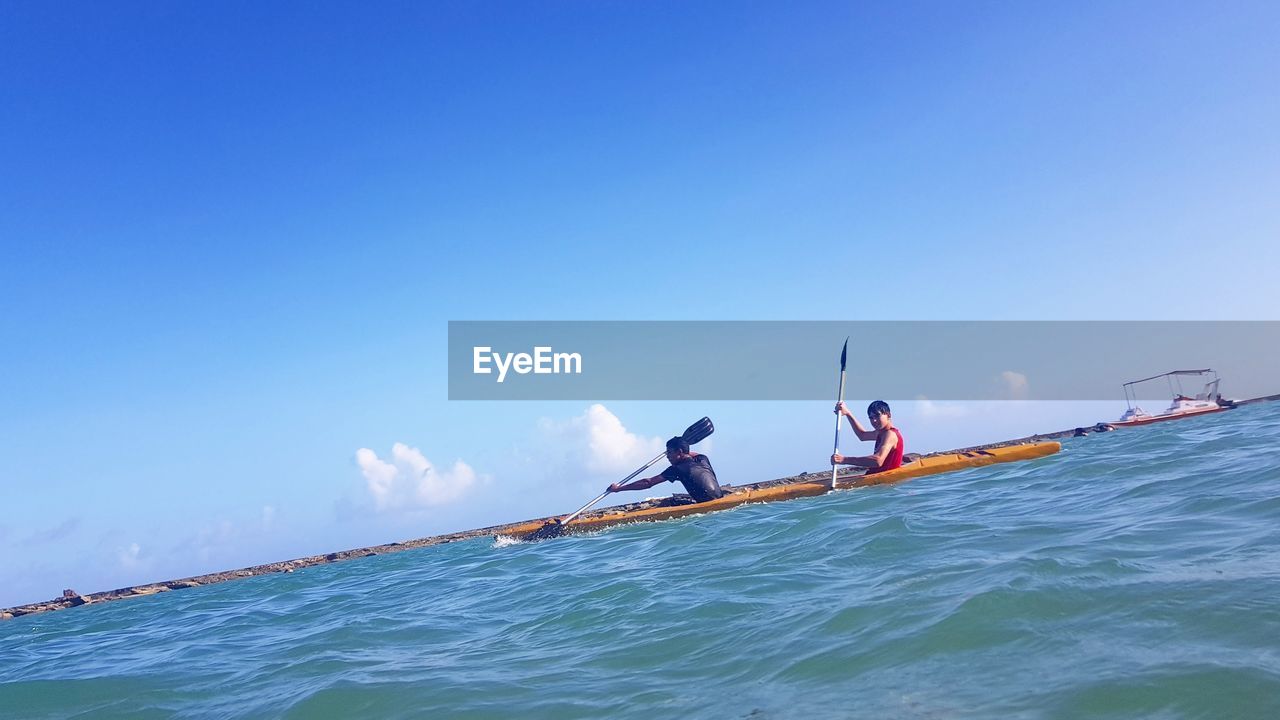 PEOPLE ON BOAT AGAINST SEA