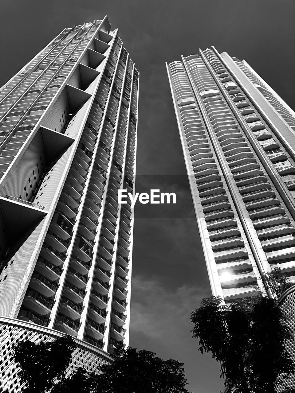 LOW ANGLE VIEW OF MODERN BUILDINGS AGAINST CLOUDY SKY