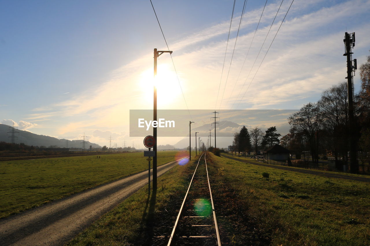 Railroad track against sky during sunset