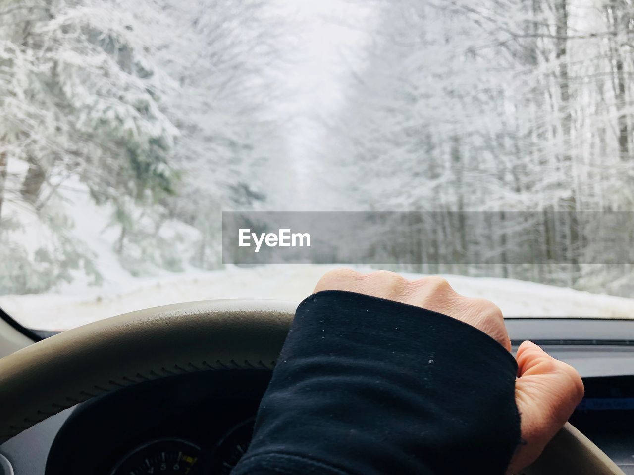Cropped hand driving car during winter