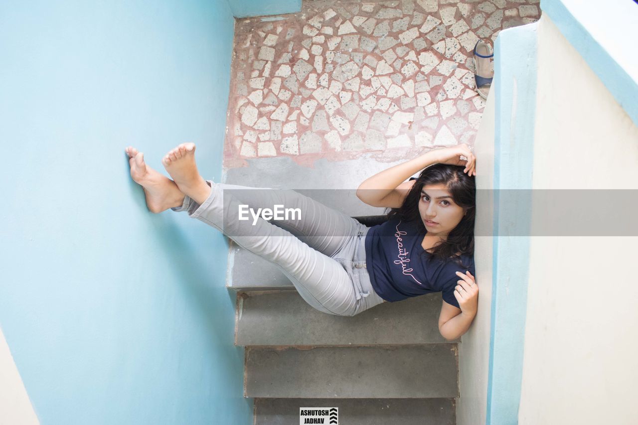 Portrait of beautiful young woman sitting on staircase