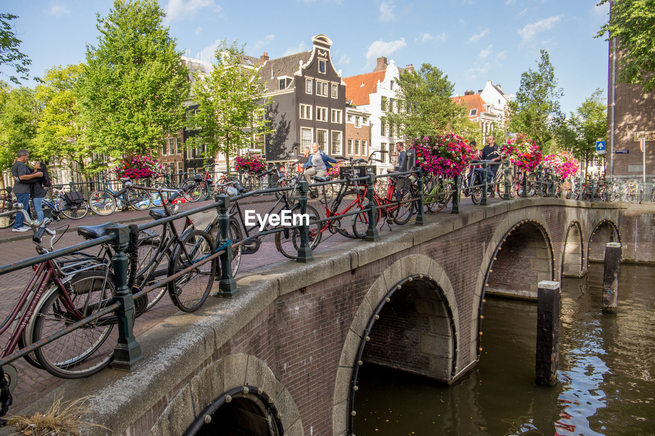 ARCH BRIDGE OVER RIVER AGAINST BUILDINGS