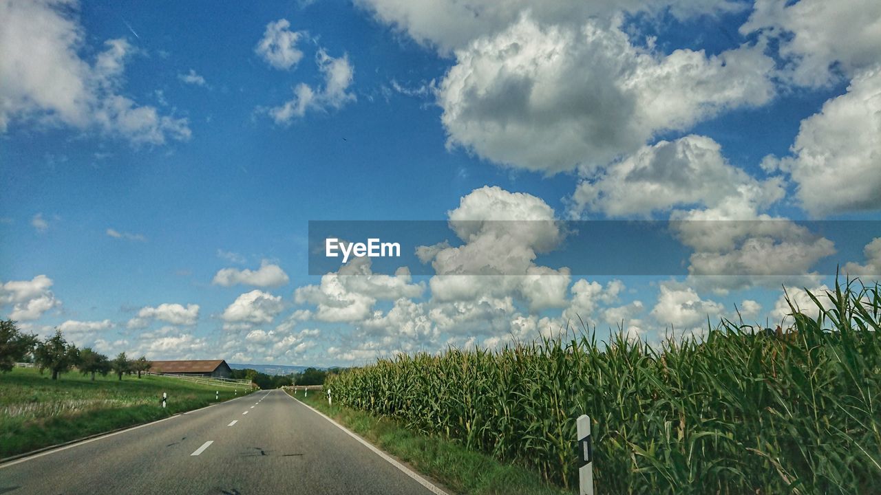 PANORAMIC SHOT OF ROAD AMIDST FIELD AGAINST SKY