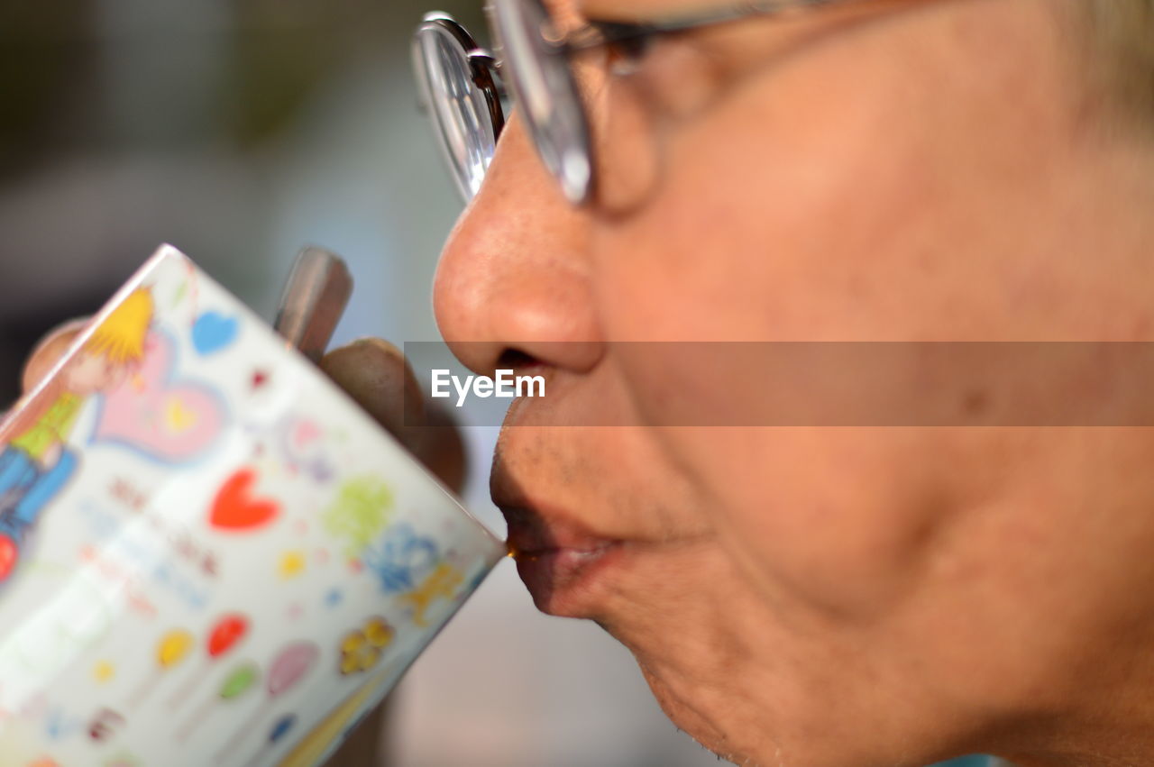 Close-up of mature man drinking coffee from cup