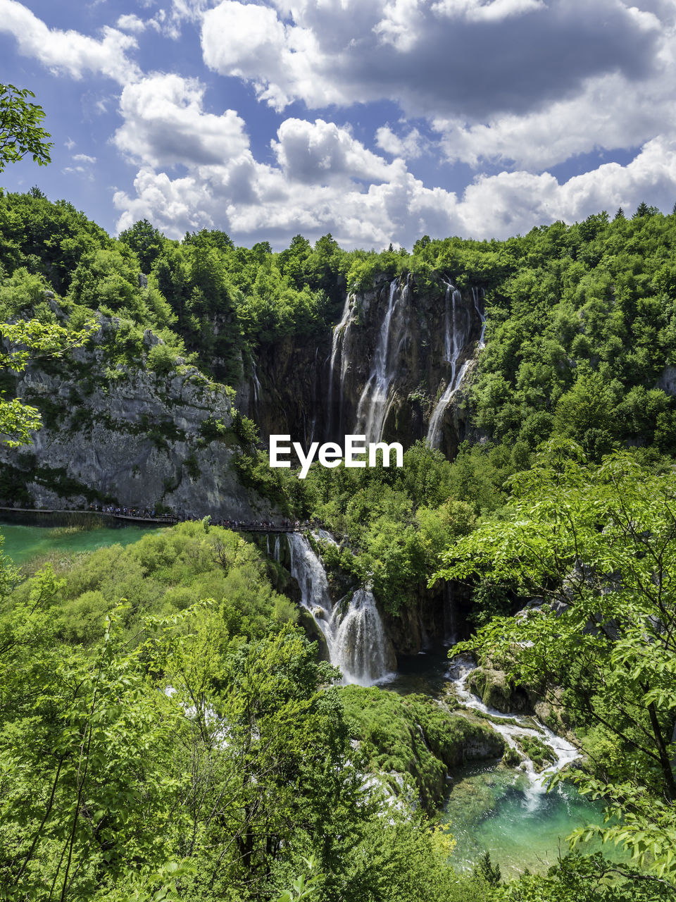 Scenic view of waterfall in forest against sky