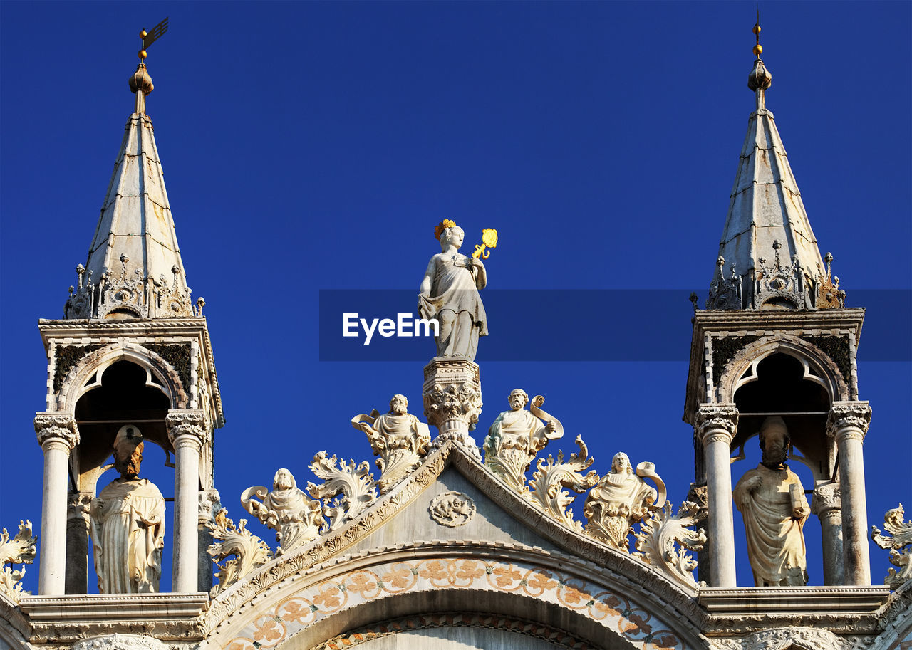 Statues and carvings on saint mark basilica against clear blue sky