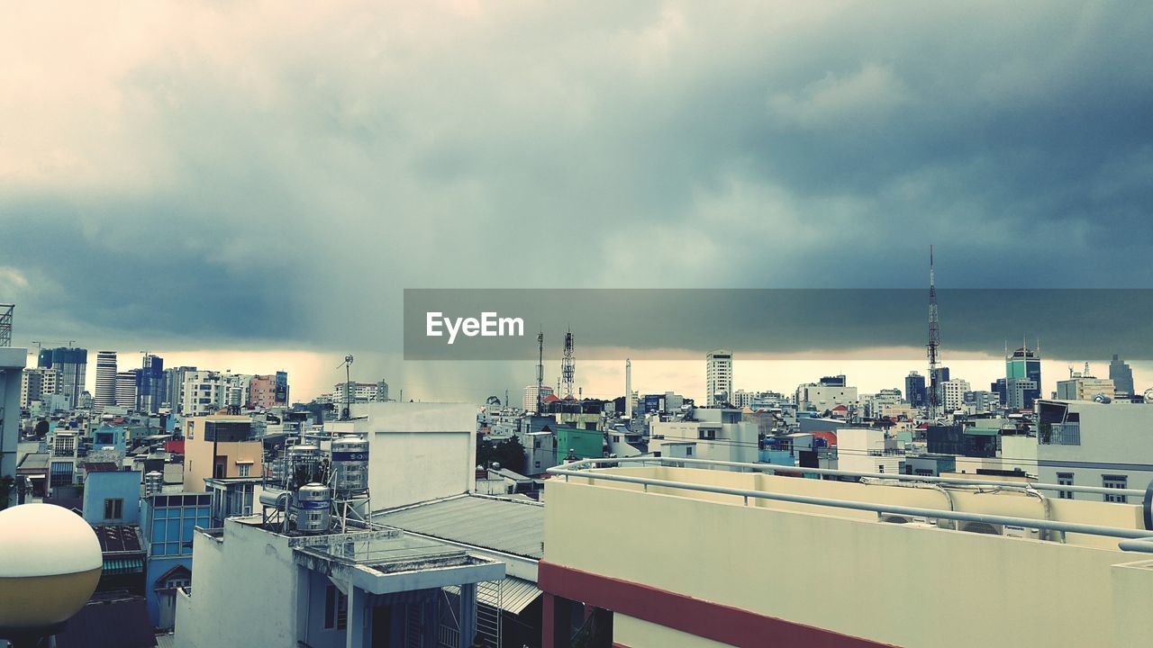 View of cityscape against cloudy sky