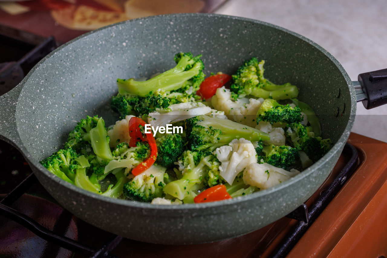 Close-up view of frying vegetables in pan without lid