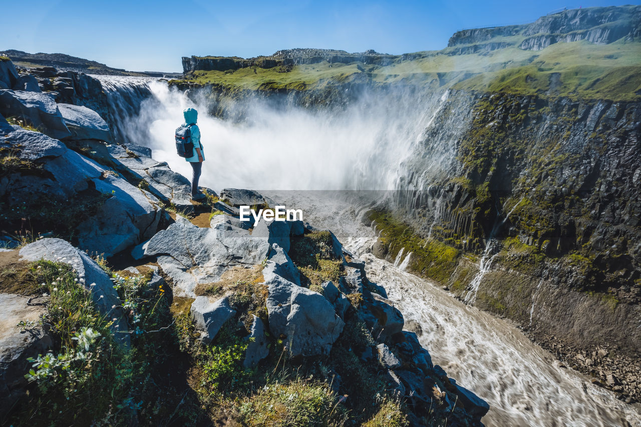 SCENIC VIEW OF WATERFALL IN MOUNTAINS