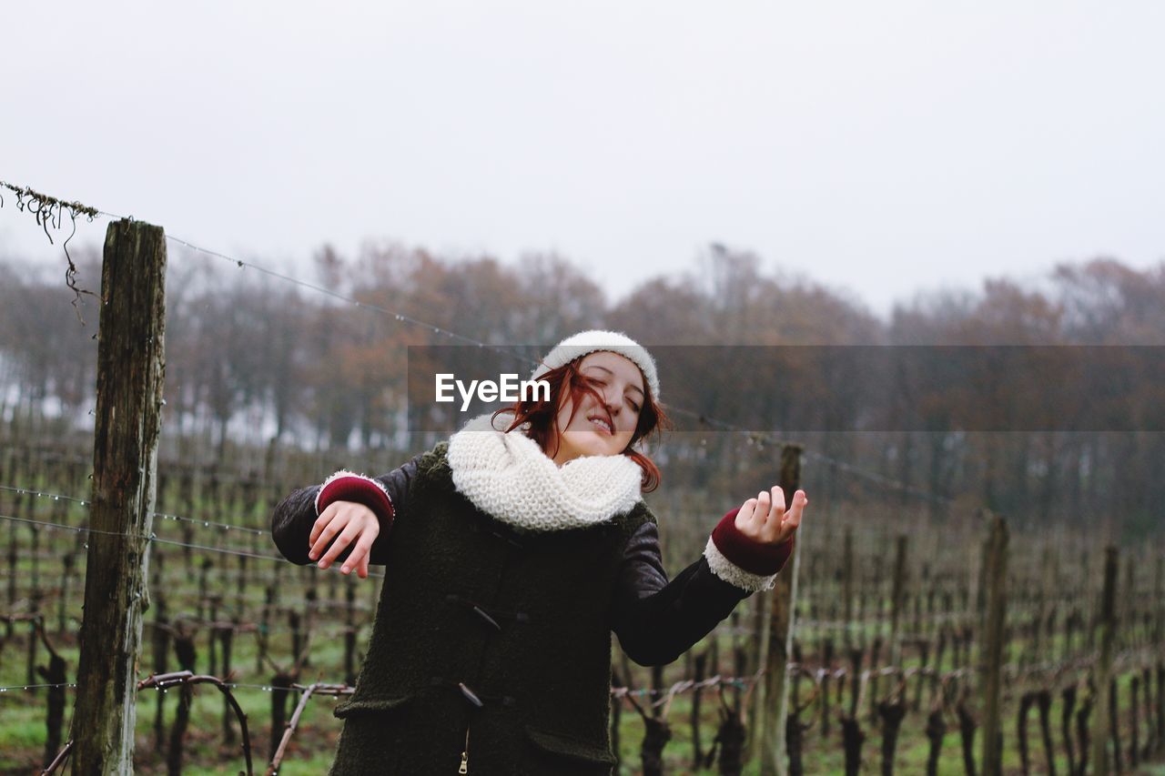 Thoughtful woman standing at vineyard