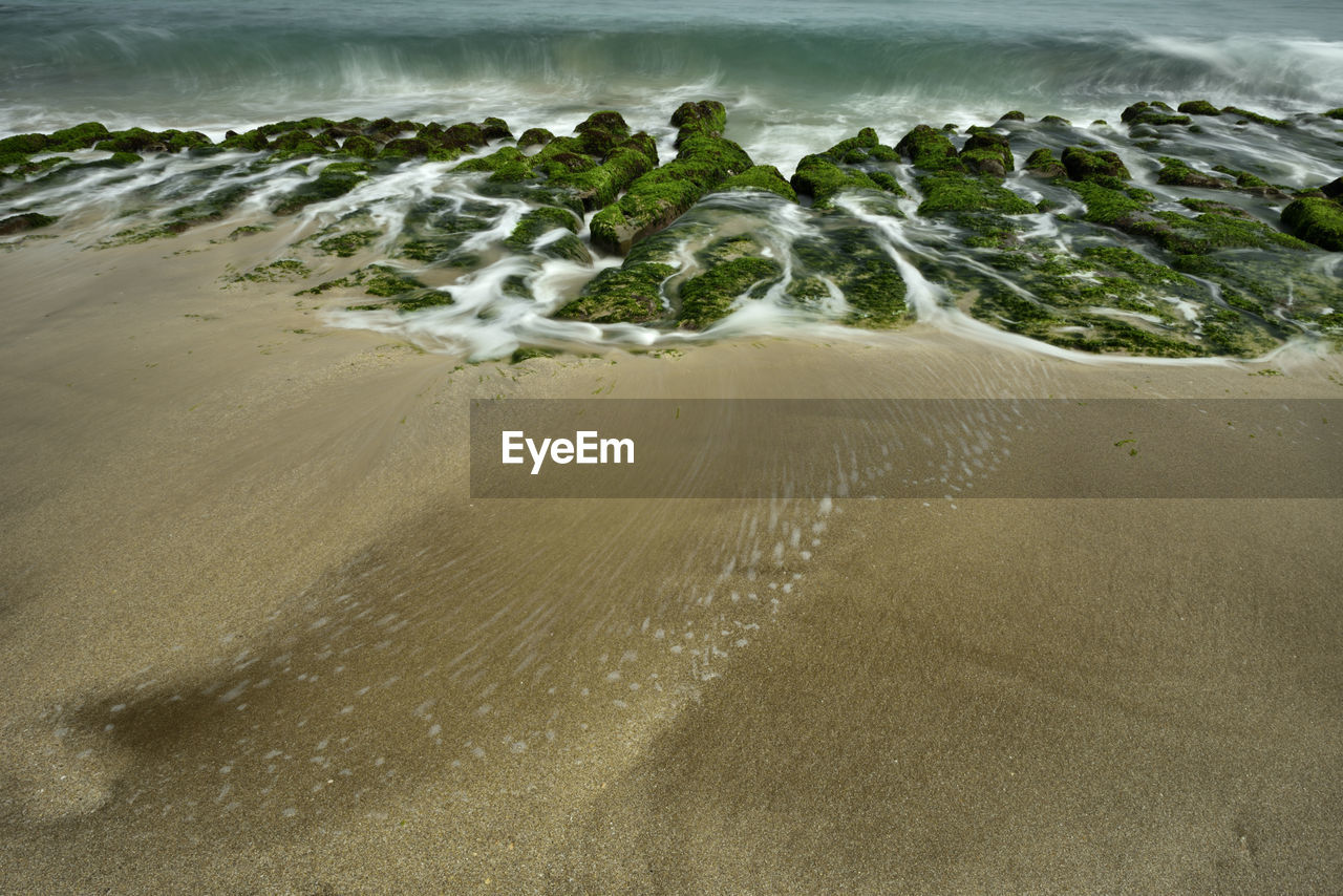 HIGH ANGLE VIEW OF WATER FLOWING AT BEACH