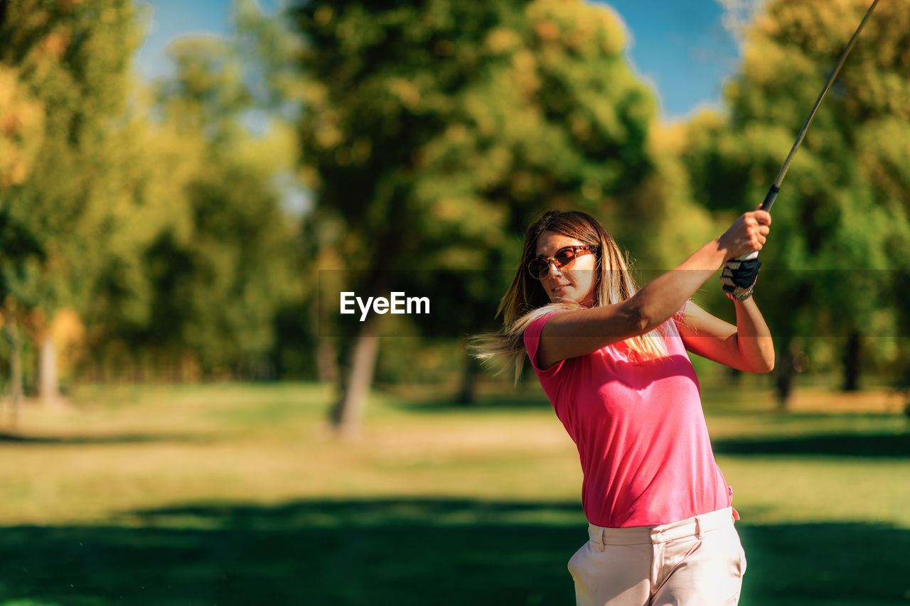 Woman playing golf on a beautiful sunny day