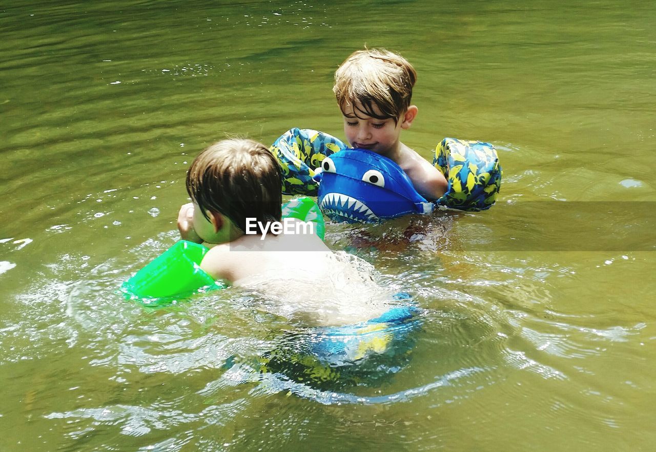 Shirtless boys swimming in lake