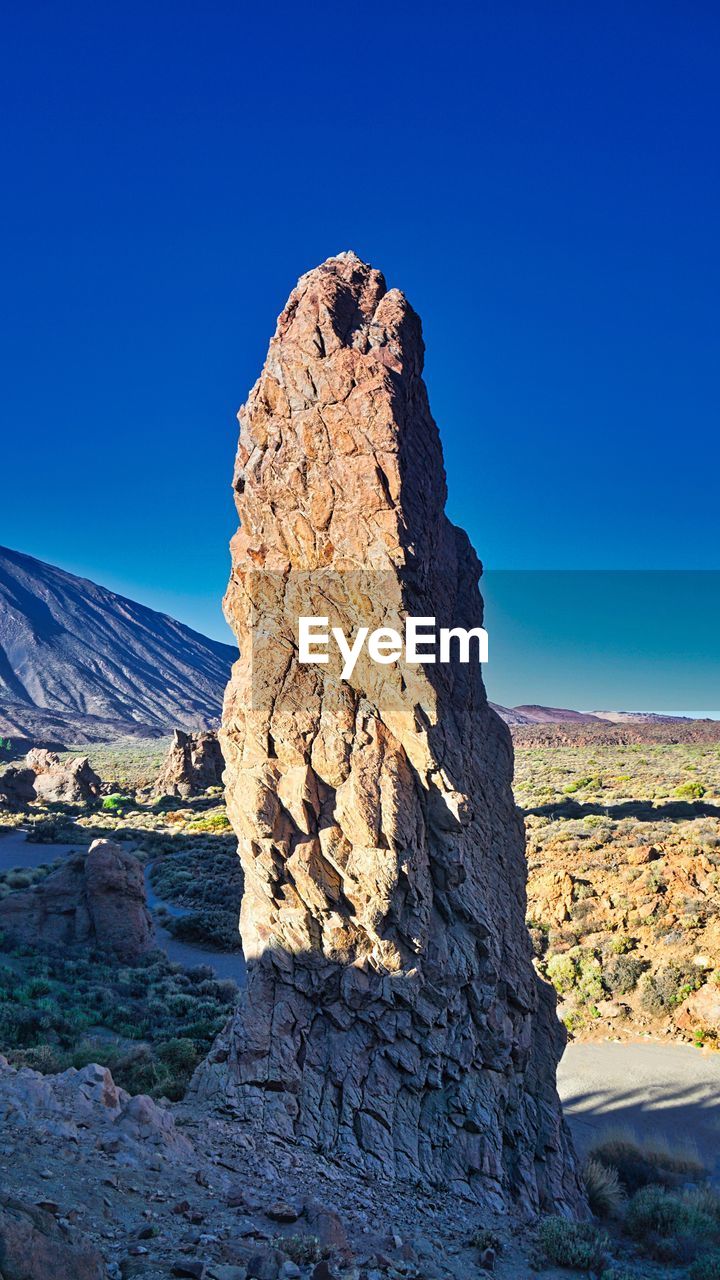 ROCK FORMATION ON LANDSCAPE AGAINST BLUE SKY