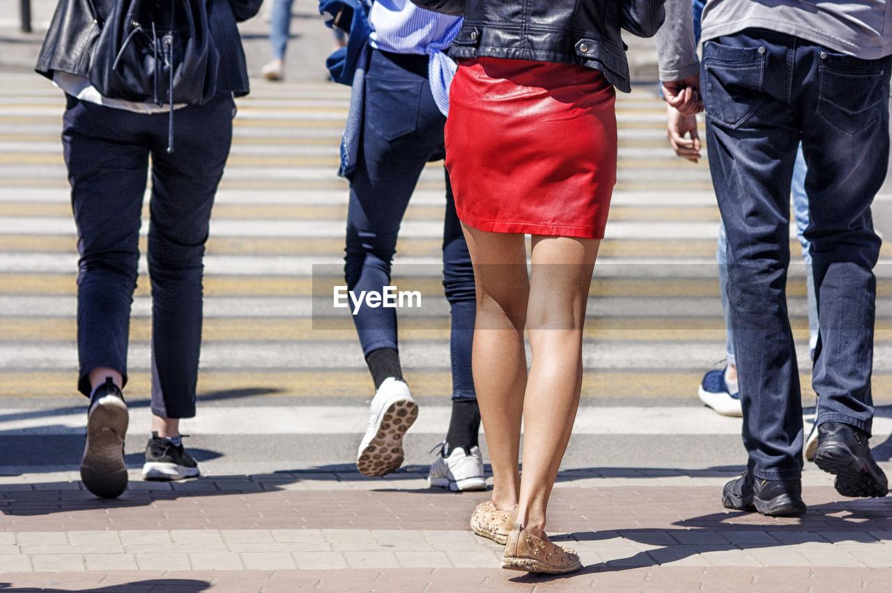 Low section of people crossing street in city