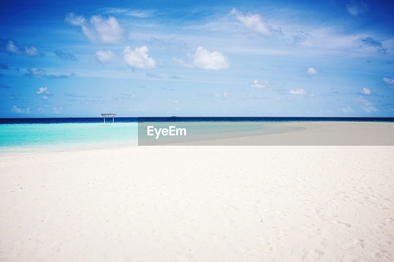 Scenic view of beach against blue sky