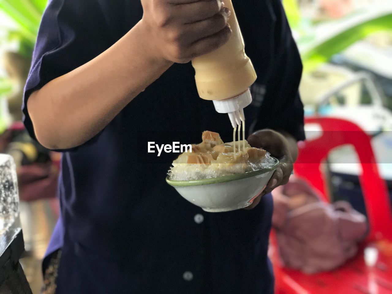 MIDSECTION OF MAN HOLDING ICE CREAM IN TRAY