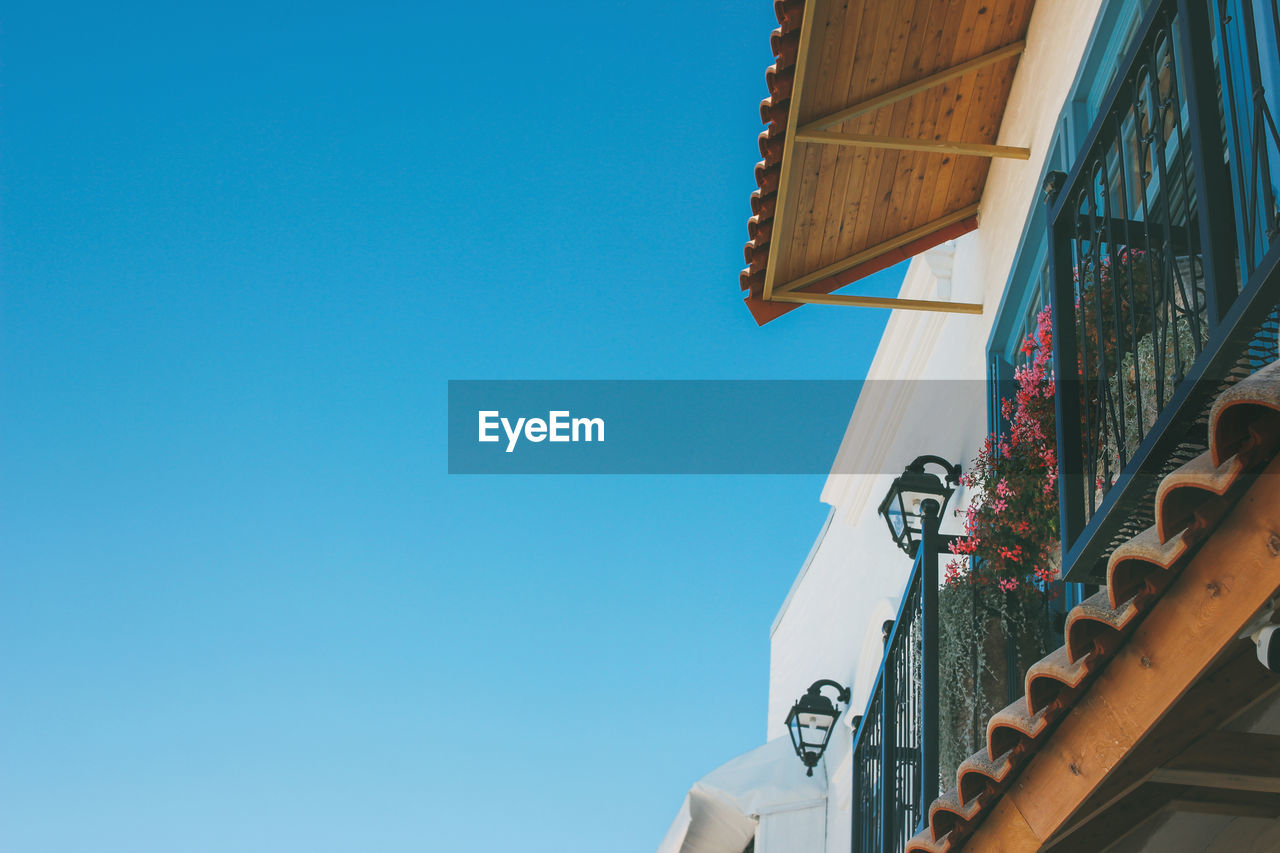 Beautiful roof facade of european cafe on the blue sky background, copy space