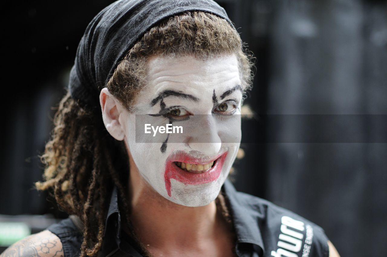 Portrait of man with painted face in city