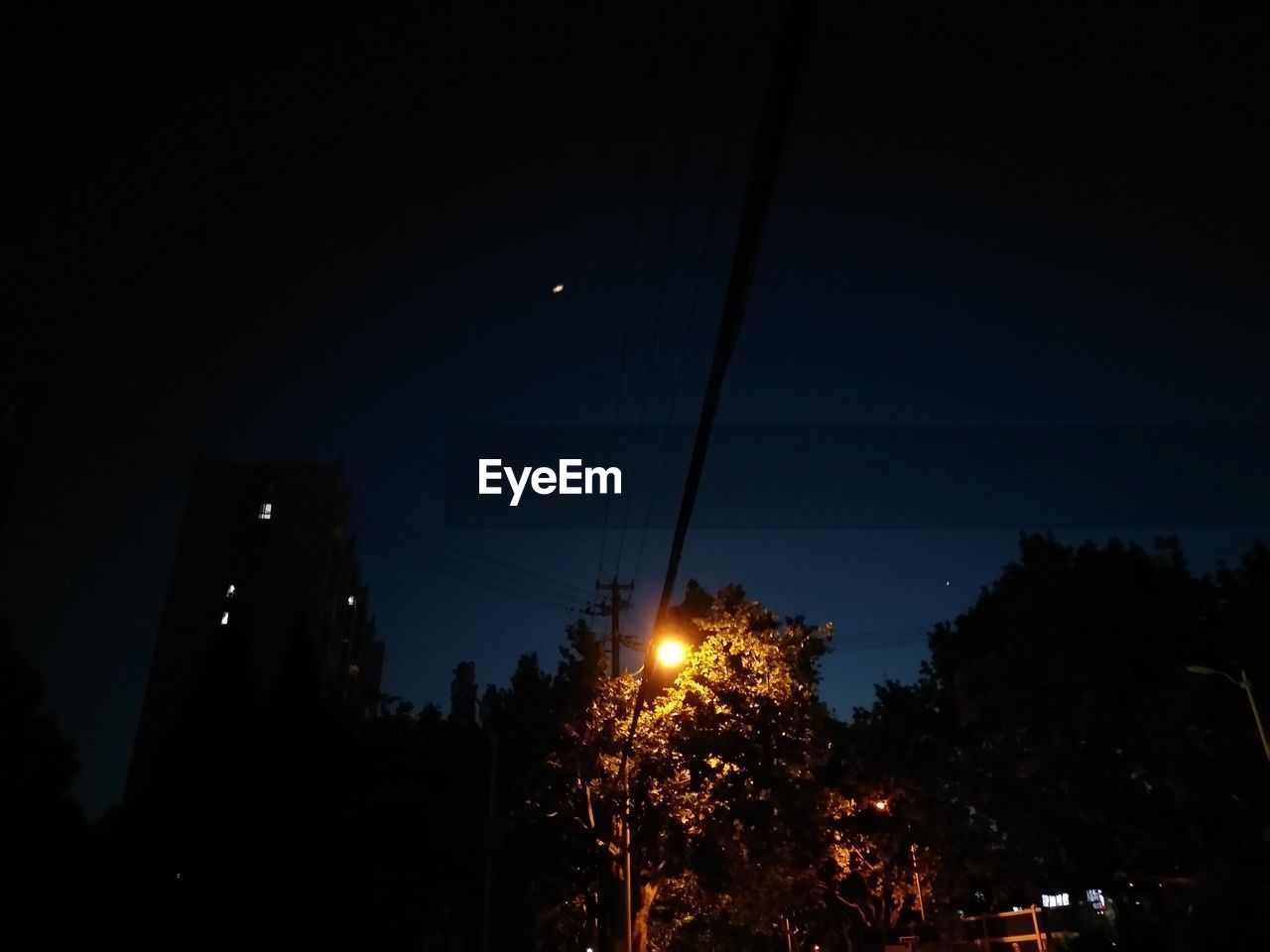 LOW ANGLE VIEW OF ILLUMINATED BUILDINGS AGAINST CLEAR SKY