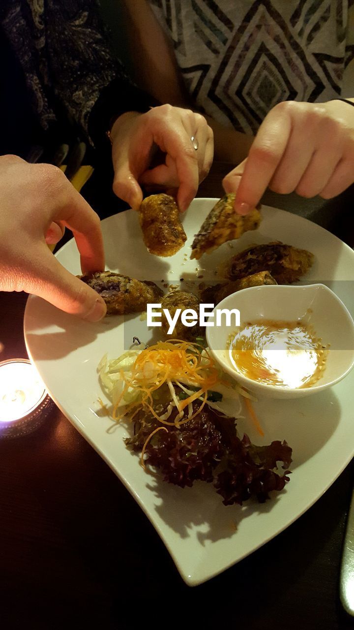 Cropped image of friends eating food