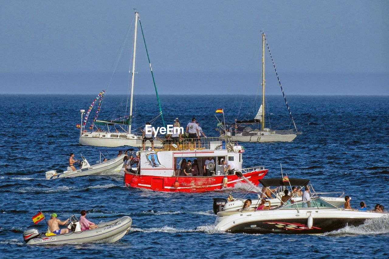 BOATS SAILING IN SEA AGAINST SKY WITH BOAT IN BACKGROUND