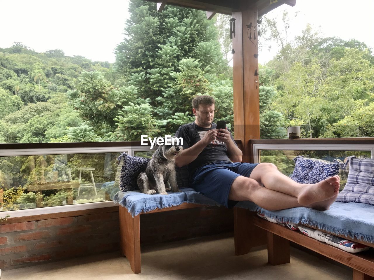 WOMAN WITH DOG SITTING BY PLANTS