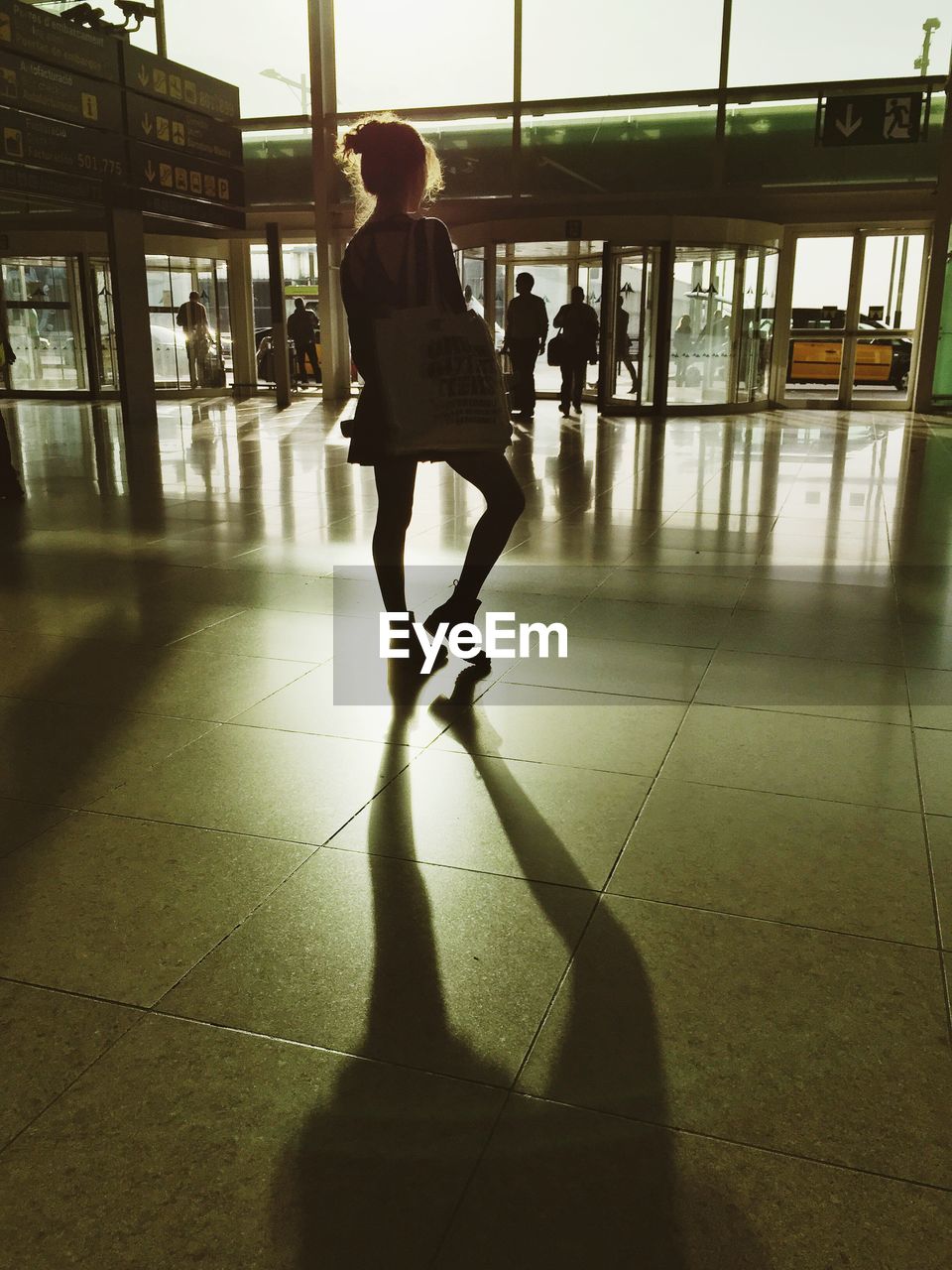 Rear view of young woman standing at airport