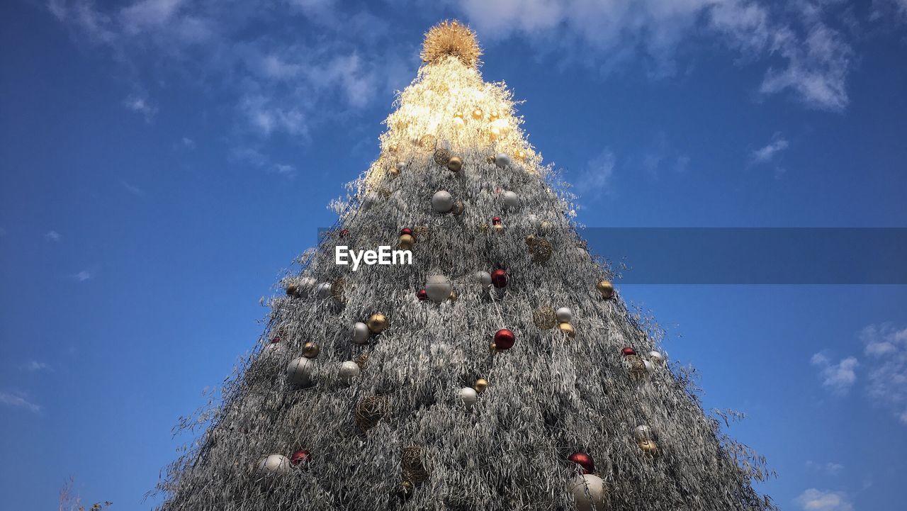 LOW ANGLE VIEW OF DECORATED CHRISTMAS TREE AGAINST SKY
