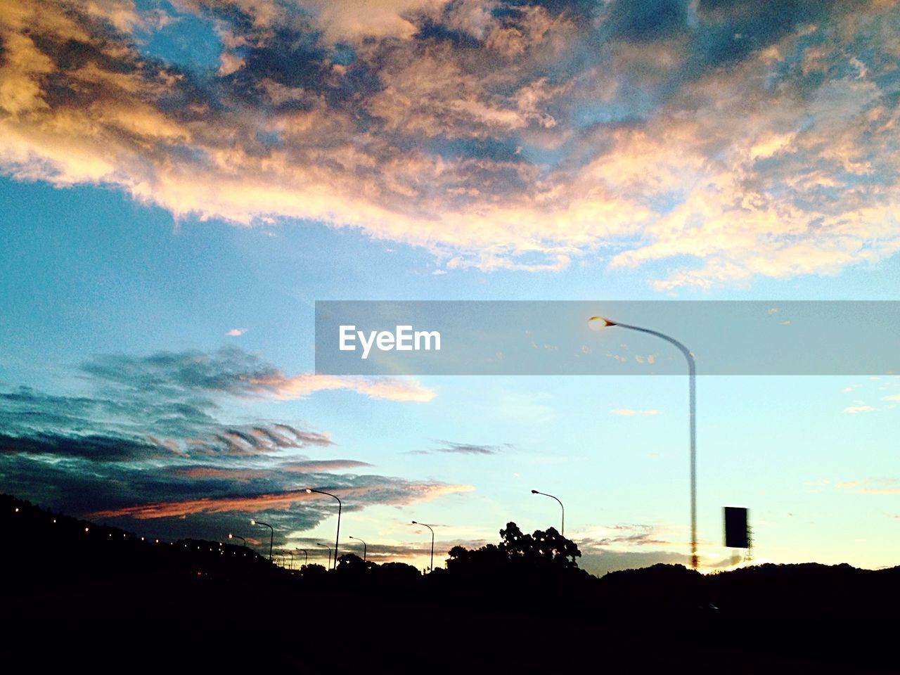 LOW ANGLE VIEW OF STREET LIGHT AGAINST CLOUDY SKY