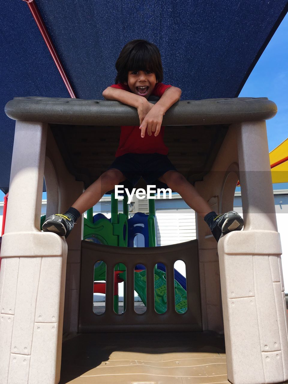 Low angle view of boy playing at playground