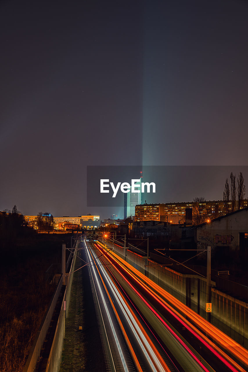 Light trails on road against sky at night