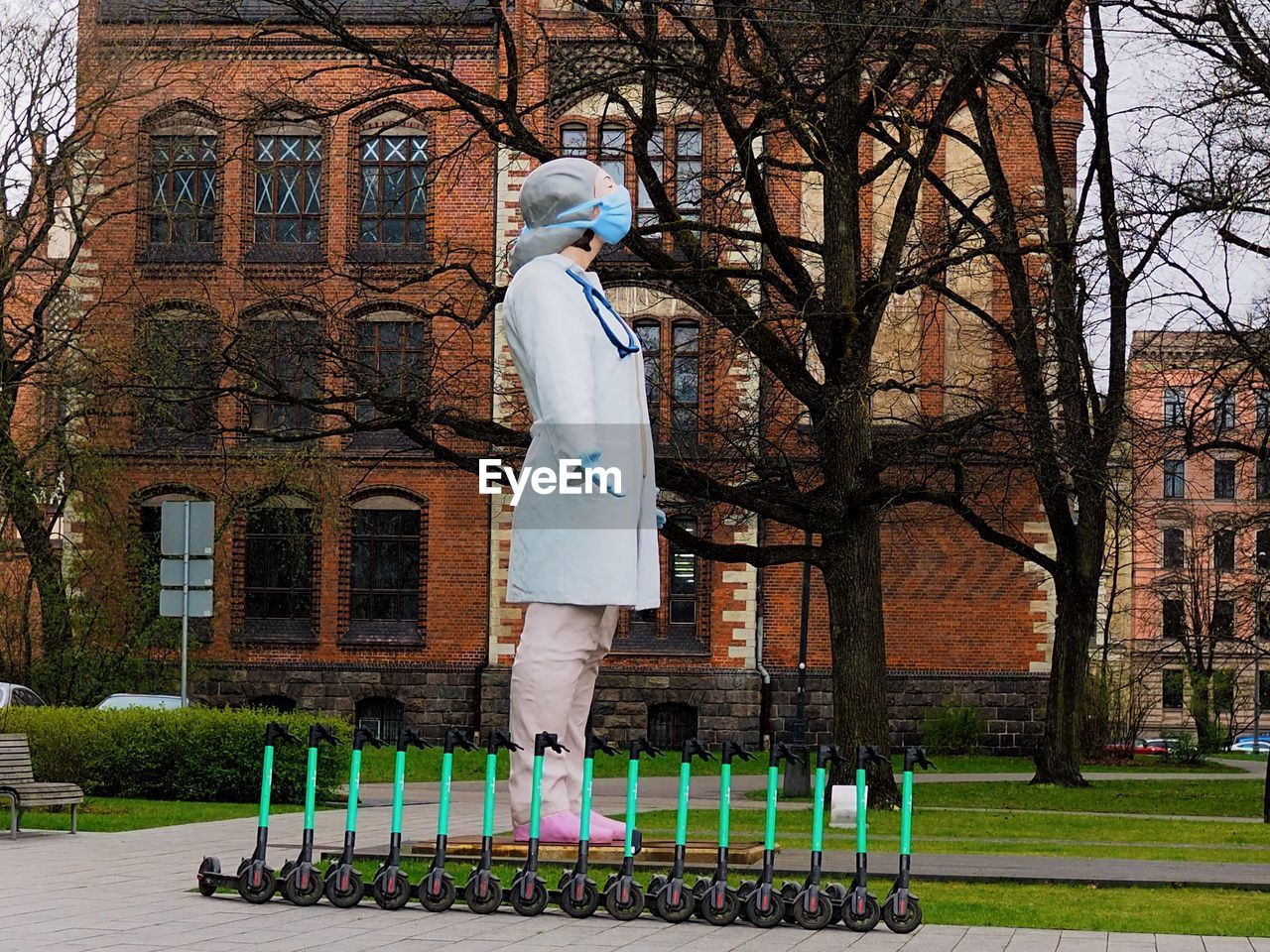 STATUE OF MAN IN PARK AGAINST BUILDING