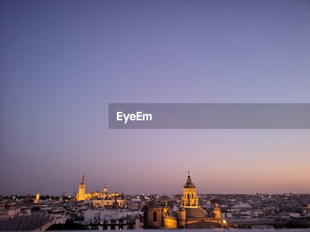 Buildings in city against sky during sunset