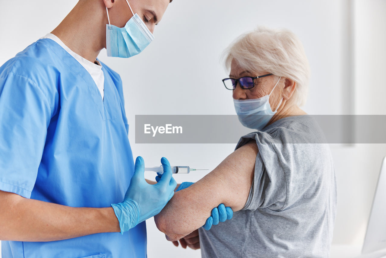 Rear view of doctor examining patient at clinic