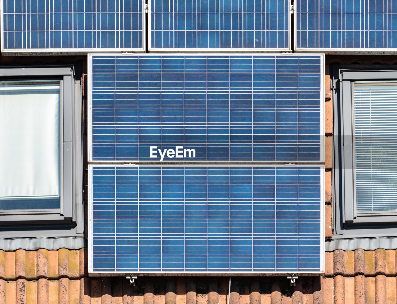 The red tilled roof covered with solar collar pannel, detail on pannels round roof windows