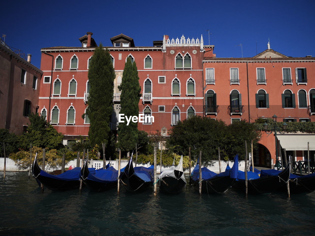 Boats moored in canal by building against sky in venezia, italy