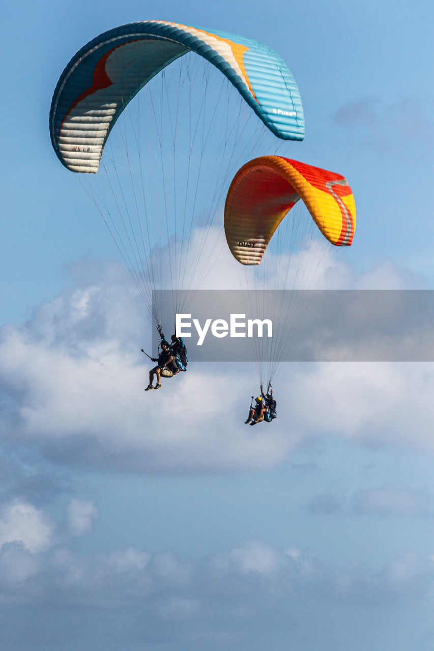 LOW ANGLE VIEW OF PEOPLE FLYING IN SKY