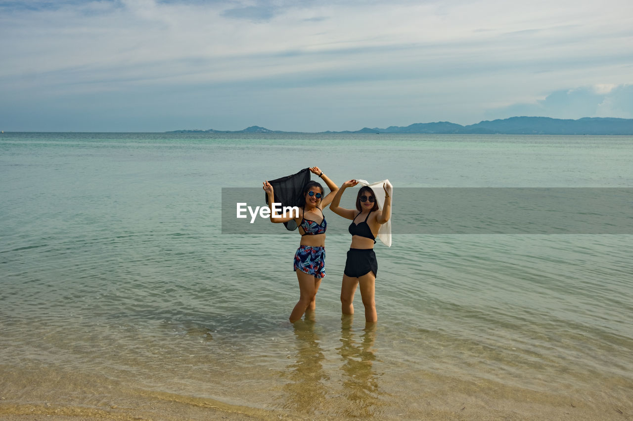 Female friends standing at beach