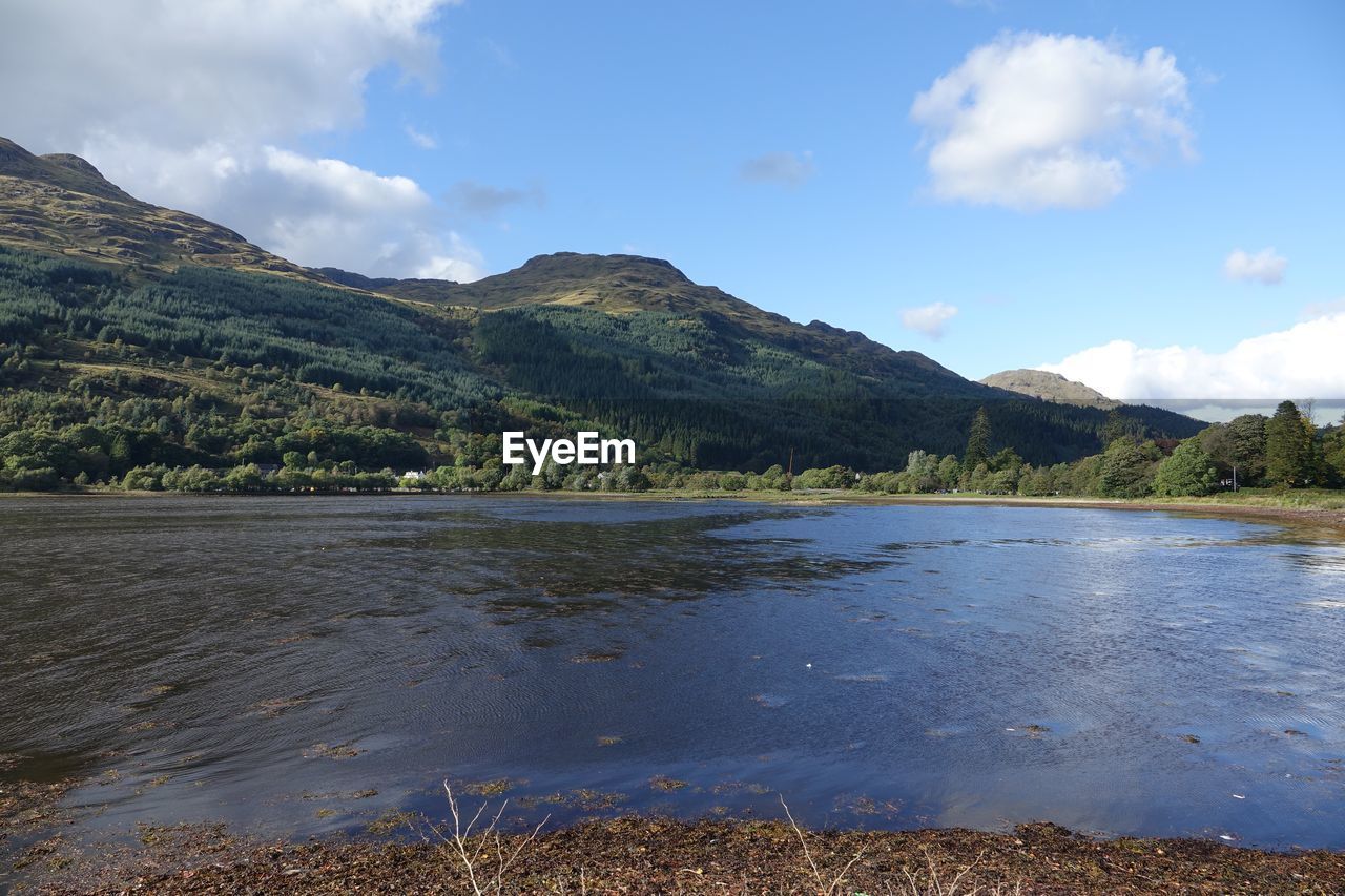 SCENIC VIEW OF LAKE BY MOUNTAIN AGAINST SKY