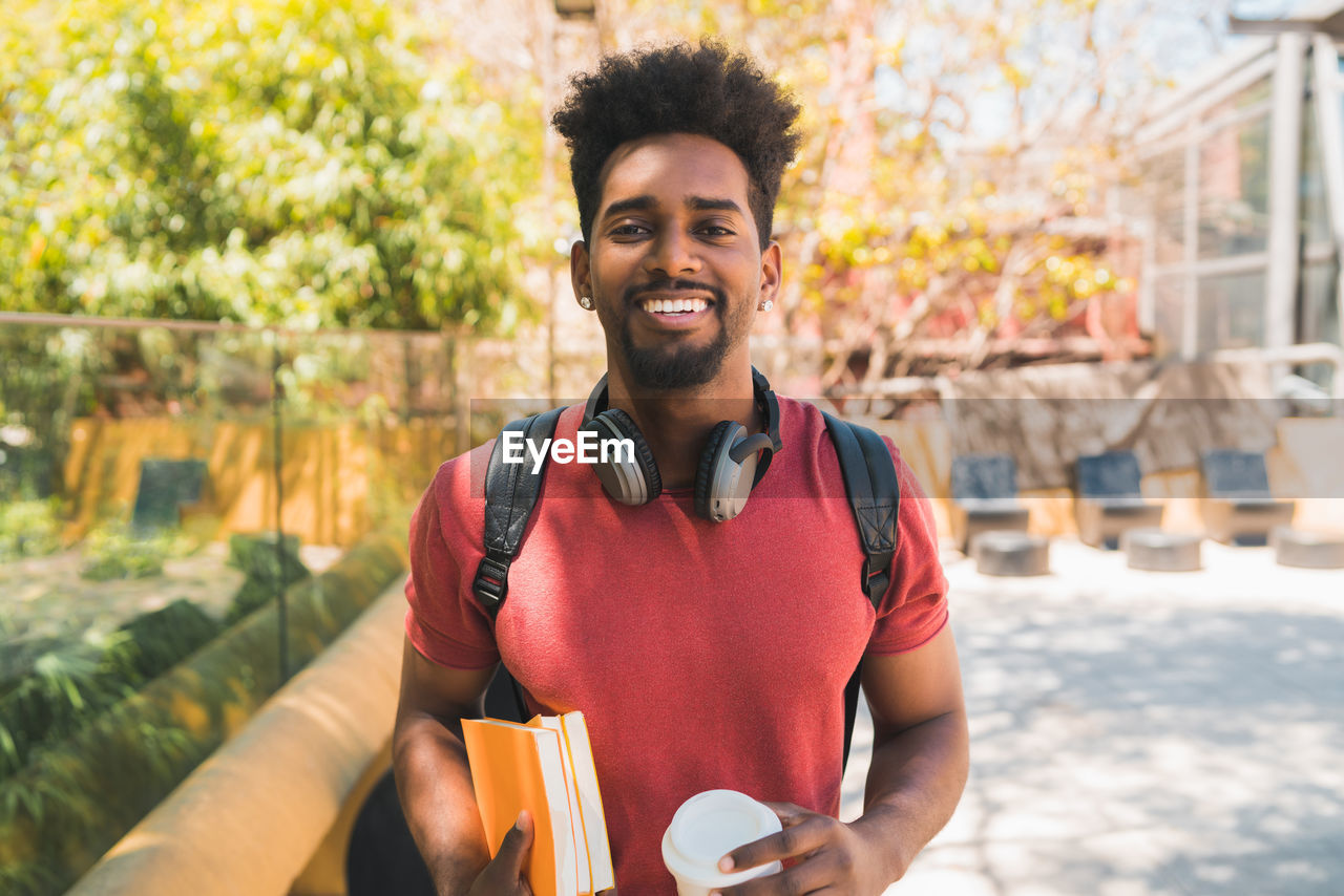 PORTRAIT OF HAPPY MAN HOLDING COFFEE CUP