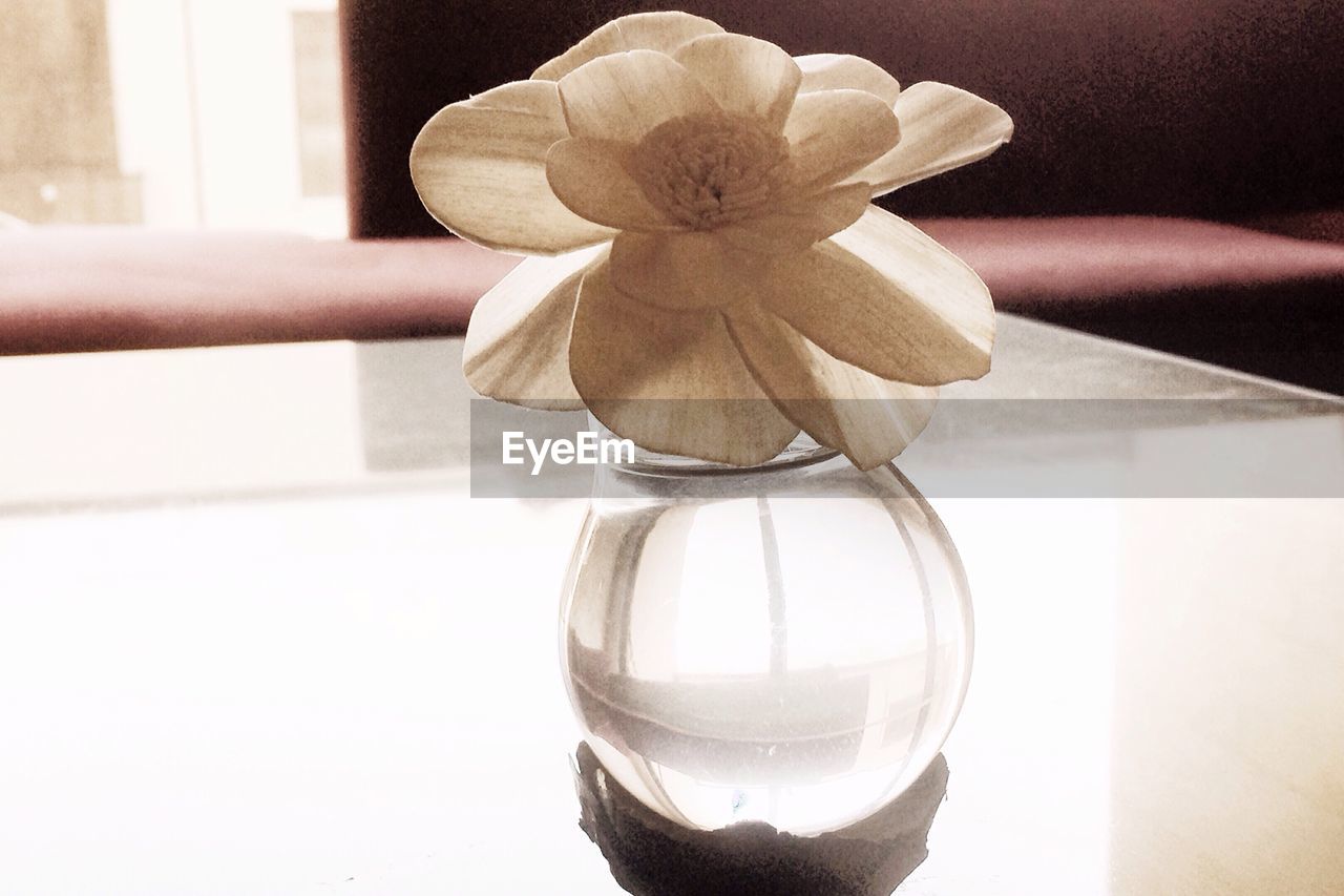 Flower vase on glass table at home