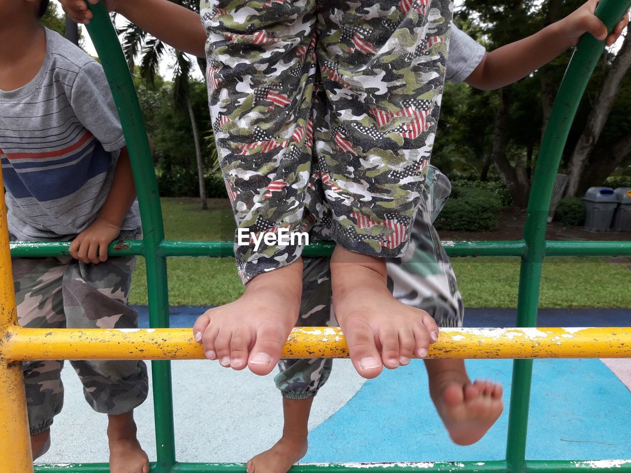 REAR VIEW OF PEOPLE STANDING ON PLAYGROUND