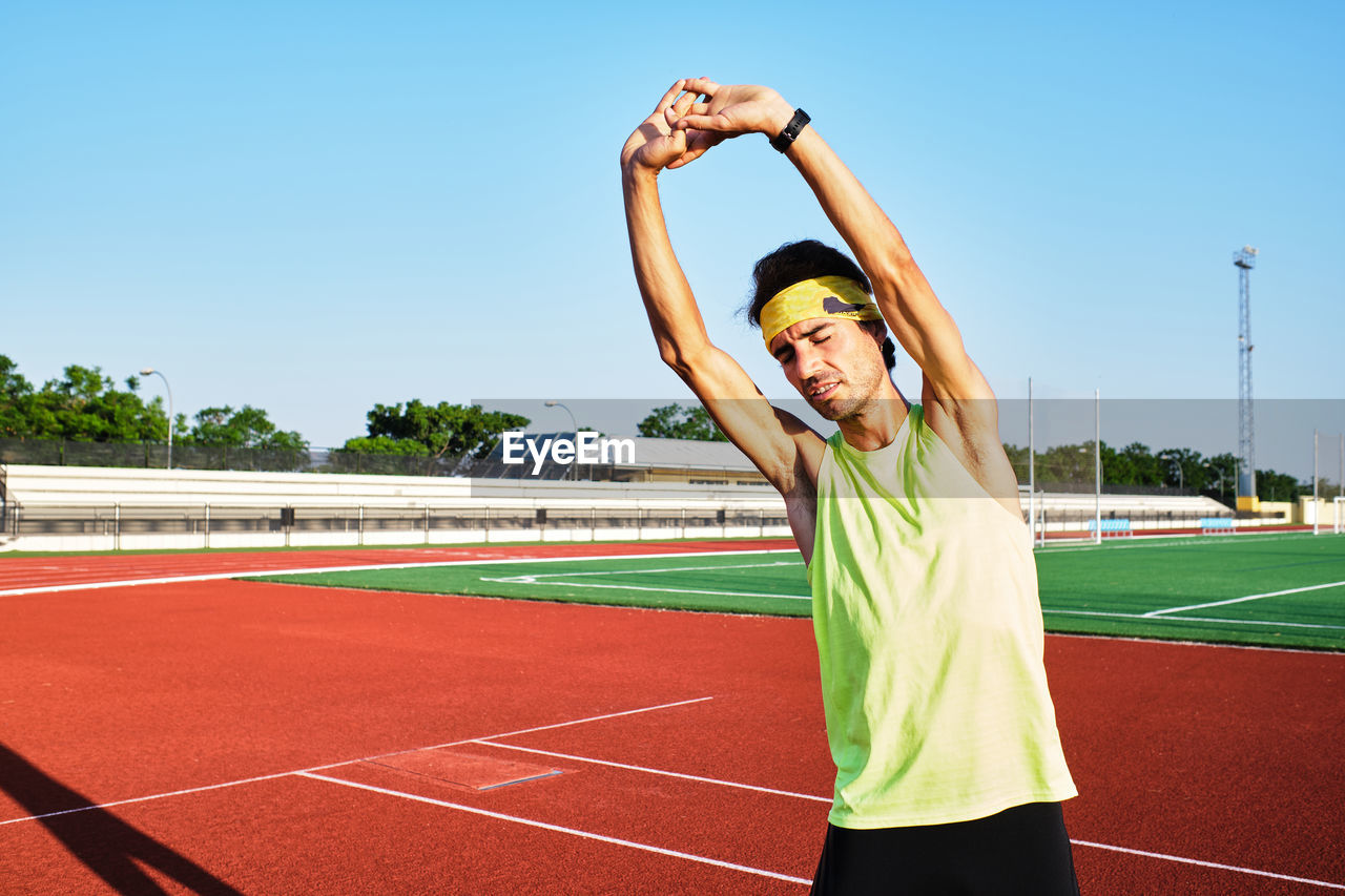 Young man practices his stretches after a hard workout