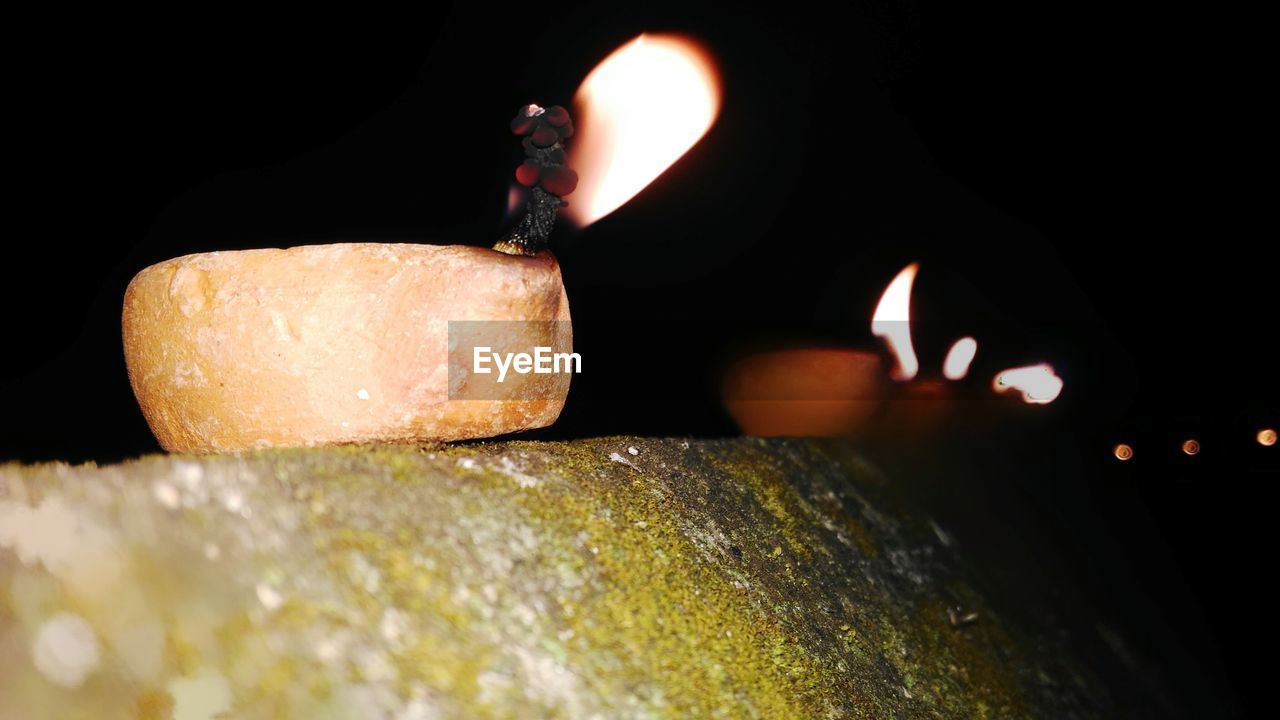 CLOSE-UP OF ILLUMINATED BURNING CANDLE