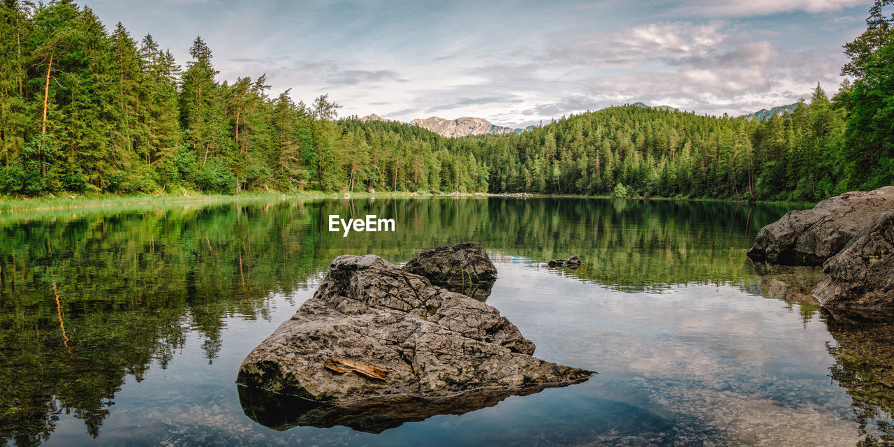 Scenic view of rocks by lake against sky