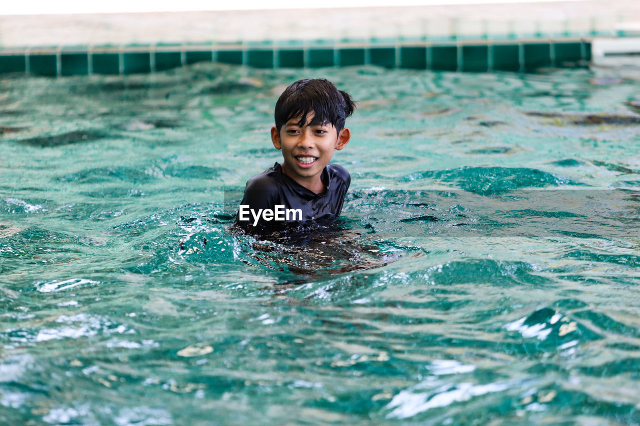 Portrait of smiling boy swimming in pool