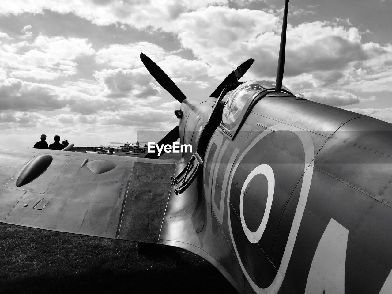 CLOSE-UP OF AIRPLANE ON AIRPORT RUNWAY AGAINST SKY